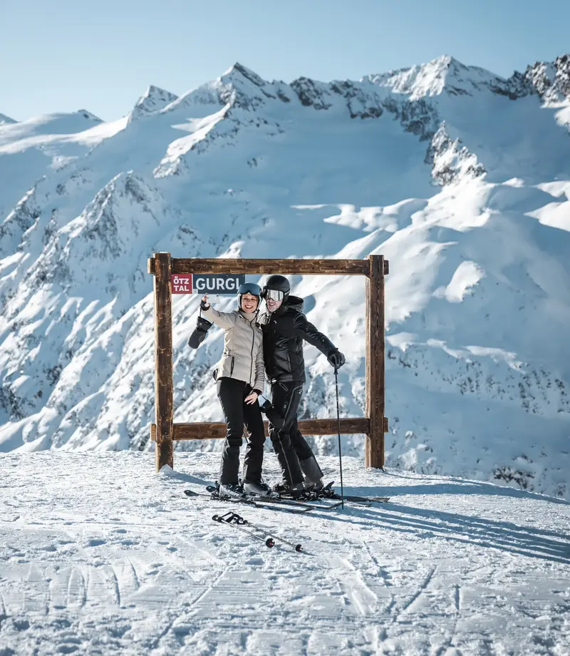 Foto-Spot im Skigebiet Gurgl Zwei Skifahrer posieren vor einem Holzrahmen mit Bergpanorama